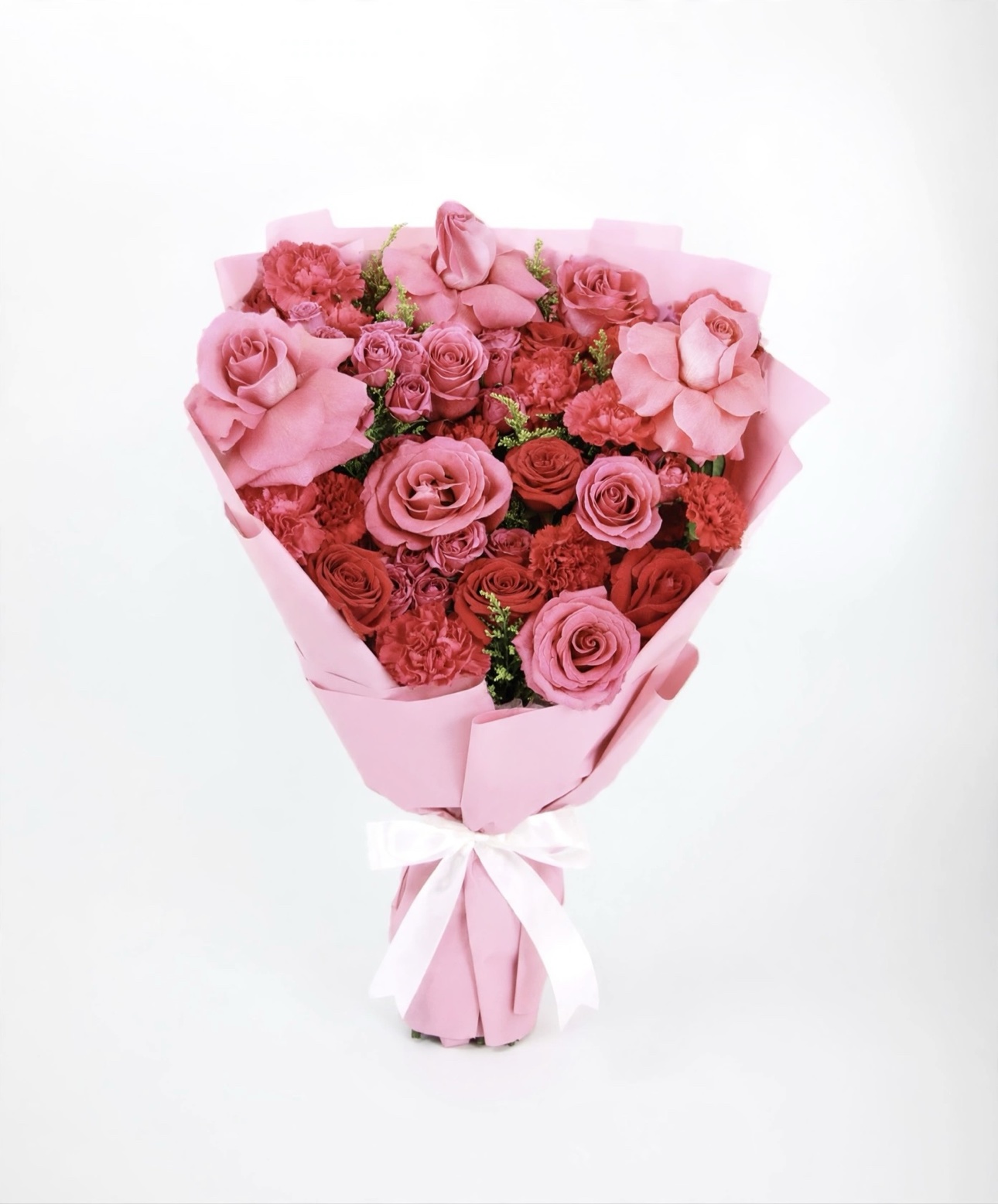 Style example for The Grand — a large bouquet of pink and red roses in pink wrap tied with a white bow